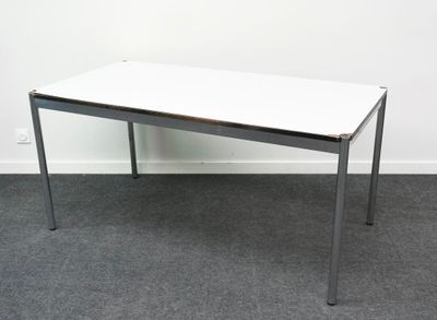 une table blanche avec un plateau noir posée sur un sol recouvert de moquette
