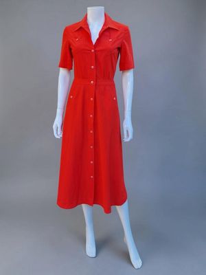 un mannequin portant une robe rouge boutonnée sur le devant