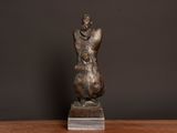 statue of a woman holding a child on a wooden table