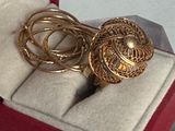 une bague en or dans un coffret rouge posé sur une surface blanche