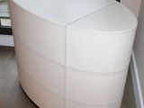 an image of a white chest of drawers in the corner of a room