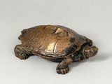 bronze figurine of a turtle on a white surface