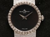 an image of a close up of a wrist watch on a black surface