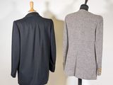 two men ' s jackets on a mannequin stand in front of a white wall