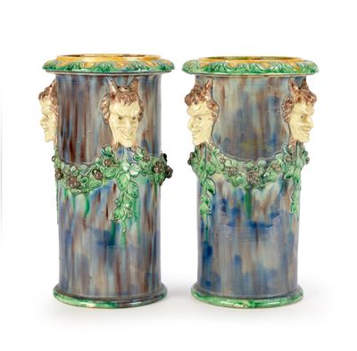 pair of blue and green vases with faces on them on a white background