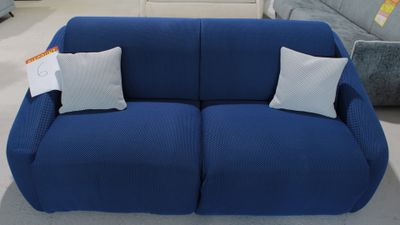 un canapé bleu avec deux coussins dessus, dans un magasin