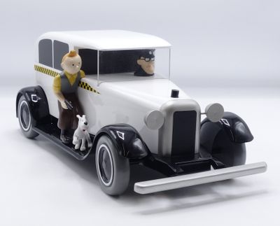 une figurine représentant un homme et un chien dans une voiture