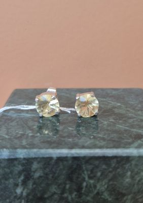 boucles d'oreilles plaquées argent ornées de cristaux transparents sur un fond en marbre