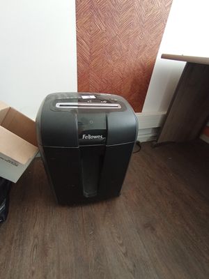 une déchiqueteuse posée par terre à côté d'un carton