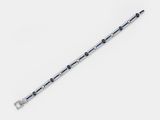 a close up of a silver bracelet with black and white beads