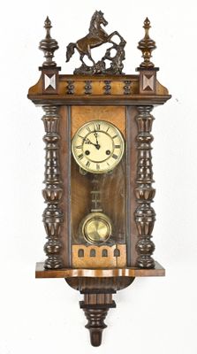 a clock that is hanging on the wall with a horse on it