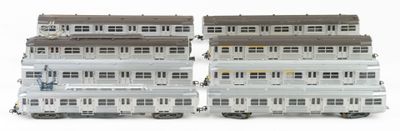 two trains that are sitting side by side on a white surface