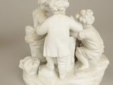 a figurine of a boy and a girl playing with a dog