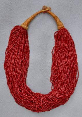 un gros plan d'un collier rouge posé sur une surface blanche
