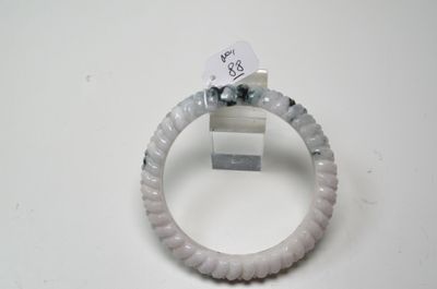 un bracelet blanc orné d'une perle noire et d'une étiquette