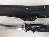a knife that is laying next to a leather sheath