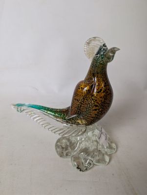 a glass bird that is sitting on top of a rock