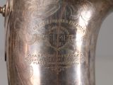 a silver vase with a gold handle on a table