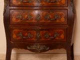 une petite commode sur laquelle est posée une horloge