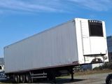 a truck that is driving down the road next to a car