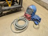 an image of a welding helmet and hoses on the floor