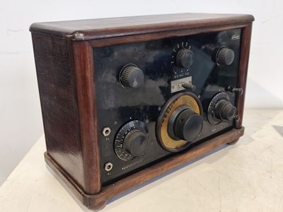 une radio à l'ancienne posée sur une table blanche