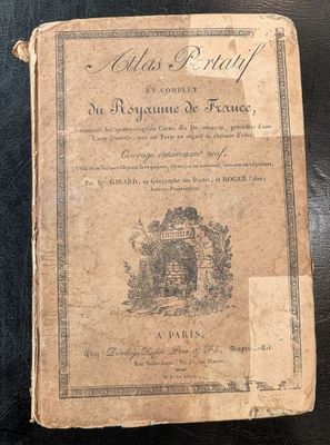 un vieux livre posé sur une table à côté d'une table noire