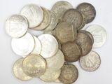 un tas d'argent et de pièces d'argent posé sur une surface blanche