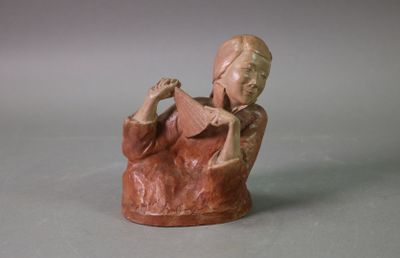 figurine of a woman reading a book on a gray surface