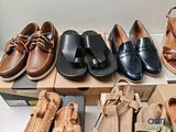 several pairs of men ' s shoes are lined up on a shelf