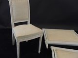 two chairs and a stool are sitting on a black surface