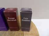 three boxes of perfume sitting on a wooden table