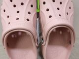 pair of pink crocs sandals with a green toothbrush on top of them