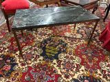 une table au plateau en marbre posée sur un tapis dans un salon