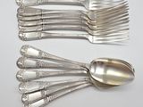 a lot of silver spoons and forks on the table