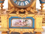 a gold clock with a picture of cherensils on it