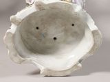 a white vase with a bird on top of it