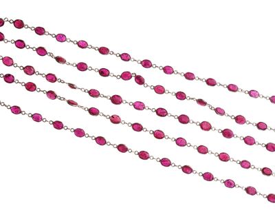 un gros plan d'un long collier de perles roses sur fond blanc