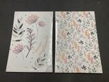 deux cartes de vœux ornées de motifs floraux, posées sur une table