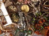 a pile of jewelry that includes a watch, bracelets, and other items