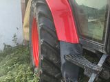 un tracteur garé dans l'herbe près d'un bâtiment
