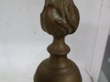 une statue en bronze représentant un oiseau posée sur une table