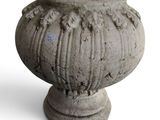 un vase en pierre posé sur une surface blanche