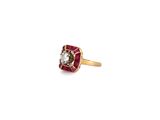a close up of a diamond and ruby ring on a white background