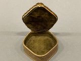 a small box with a ring inside of it on a table