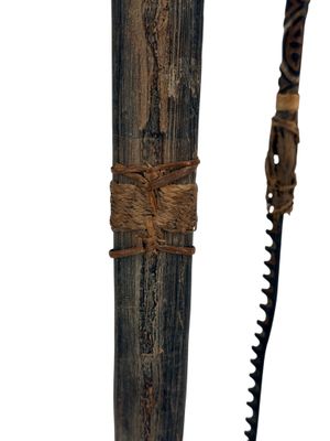 a knife that is tied to a wooden pole