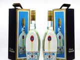 two bottles of vodka are sitting next to each other on a white surface
