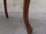 a close up view of a wooden chair with a black seat