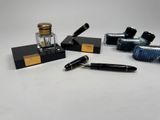 plusieurs stylos et encriers posés sur une table blanche