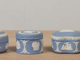 three blue and white ceramic containers sitting on a table